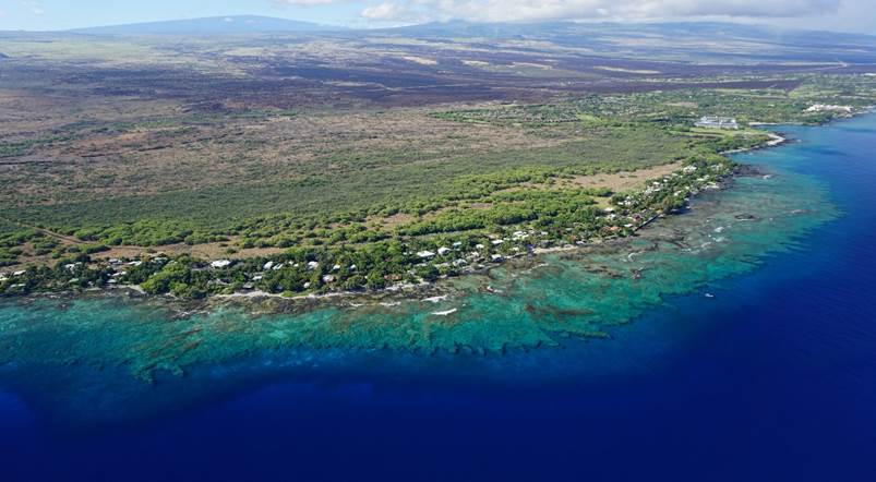 Aerial view of the Puakō, Hawai‘i coastline showing the coral reef that spans the length of the entire coast.